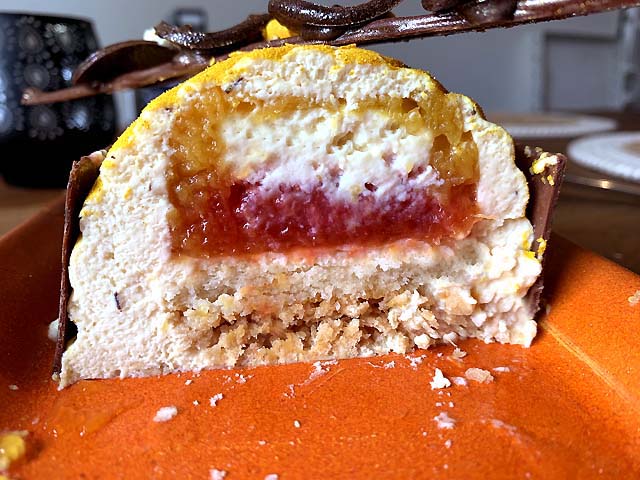 Entremets exotique et raffiné composé de biscuit moelleux, compotée mangue-passion, bavaroise au thé rooibos maracuja, crémeux vanille et glaçage miroir passion, une création pâtissière qui évoque l’été en plein hiver