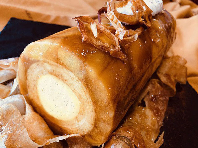 Buche tatin, aux pommes caramélisées au four, avec un insert crémeux à la vanille, enveloppé dans un biscuit joconde et mousse au skyr