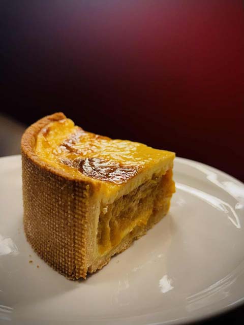 Découpe du flan vanille-mirabelle, crème fondante à la vanille, insert fruité et pâte sucrée aux amandes