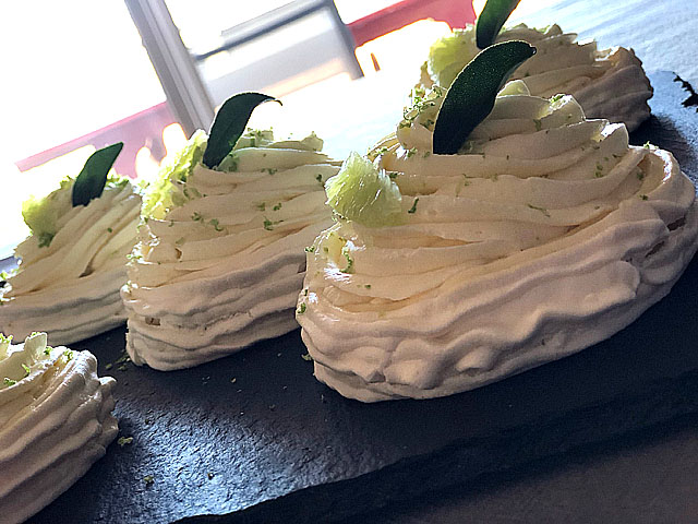 Dessert individuel à la meringue suisse, confit kalamansi, crémeux citronnelle au rhum ambré et ganache montée au chocolat blanc, décoré de zestes de citron vert