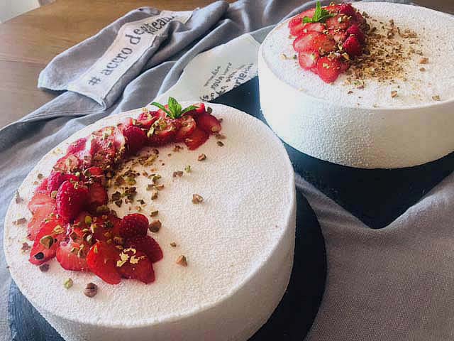 Un gâteaux d'anniversaire gourmands à la pistache te mousse compotée de framboise, enveloppé dans une souple mousse à la vanille de Madagascar