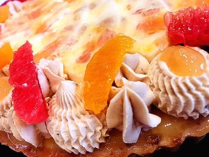 Une onctueuse tarte aux agrumes, pamplemousses, mandarines, et litchis, agrémentée d'une ganache namelaka montée au chocolat blanc
