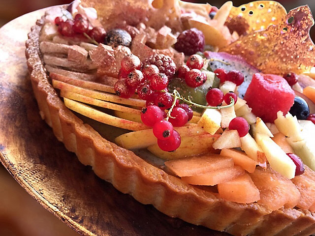 Tarte aux fruits colorée sur pâte sucrée dorée, garnie de crème diplomate légère et fruits frais de saison