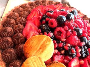 Tartes d'été, aux fruits rouges, ganache montée au chocolat noir, posée sur une compotée de fruits rouges et noirs