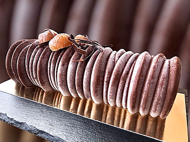 Part de bûche de Noël aux noisettes, marrons et chocolat servie pour les fêtes de fin d’année