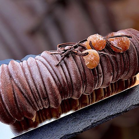 Une bûche de Noël, idéale pour terminer l'année, composée de crème d'une marrons de Collobrières, biscuit dacquoise aux noisettes, et d'un savoureux insert d'oranges confites et de chocolat noir