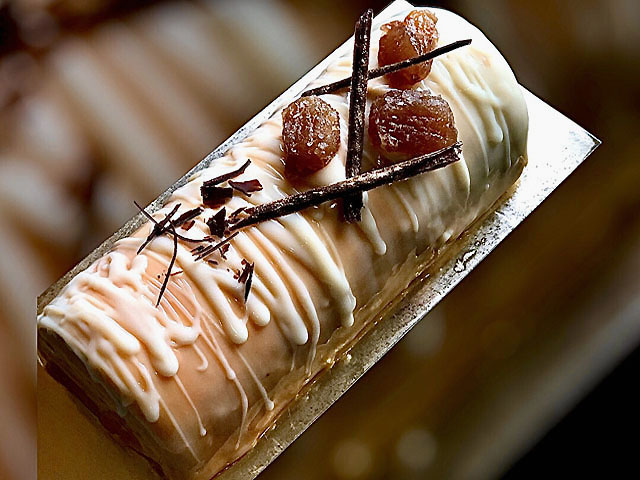 Bûche de Noël marrons pamplemousse sur une table festive