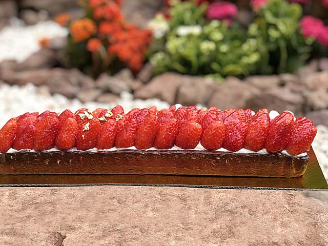 détail de tarte aux fraises maison avec mousse chocolat blanc vanille et glaçage brillant praliné