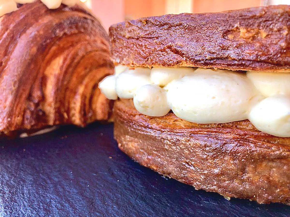 Gros plan sur la crème diplomate à la fève de tonka et le confit de mirabelles dans une brioche tropézienne
