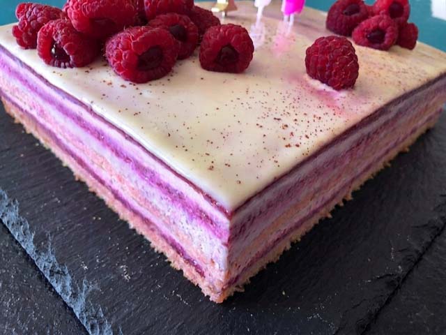 Entremets framboise litchi avec glaçage brillant, mousse légère au fromage blanc et décoration de fruits rouges