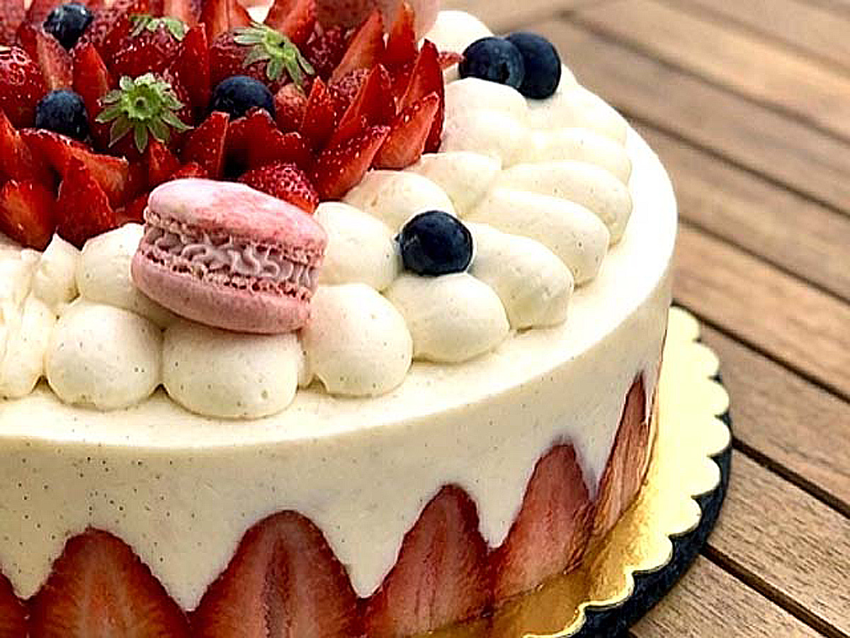 Fraisier crème diplomate vanille décoré de fraises fraîches et macarons à la fraise