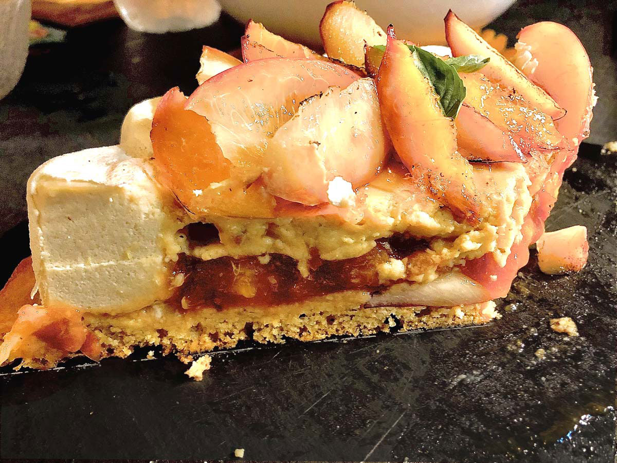 Coupe de tarte aux nectarines et à la verveine révélant la mousse, le crémeux et la compotée de fruits